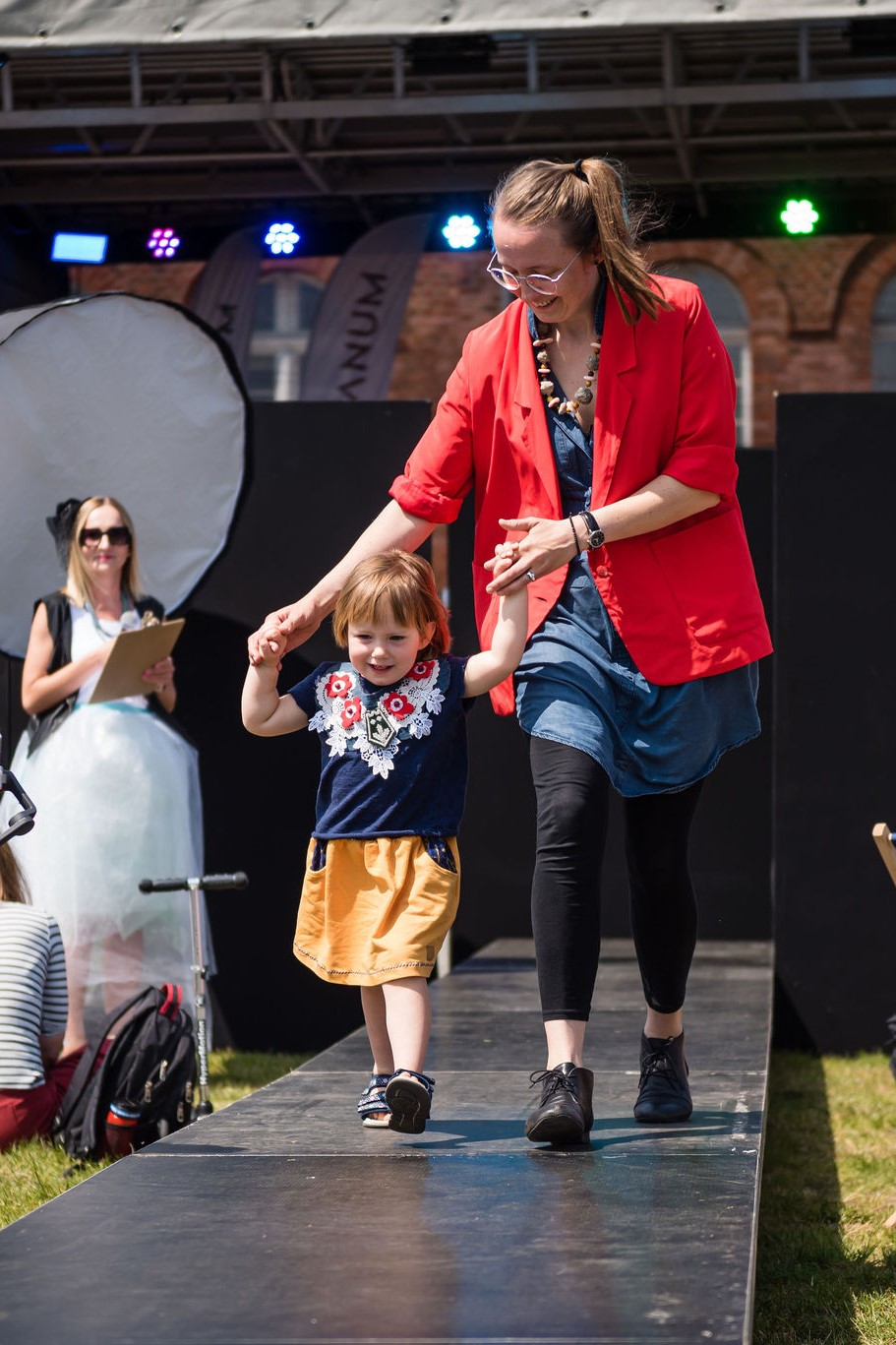 Kobieta z dzieckiem biorące udział w pokazie mody zero waste